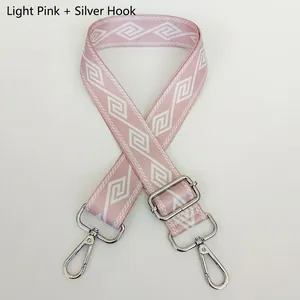 Detail of adjustable wide bag strap in light pink with geometric weave and silver hooks