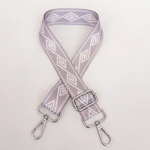 Detail view of the wide woven strap in light purple with geometric patterns and silver hooks