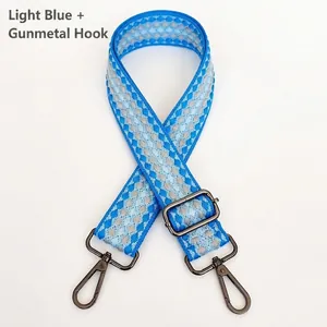 Detail of light blue plaid woven bag strap with gunmetal swivel hooks and slider