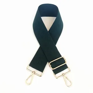Detail of adjustable dark green canvas strap with twill texture and gold metal hooks