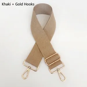 Close-up of adjustable khaki canvas bag strap with durable gold metal hardware clips