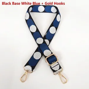 Close-up of adjustable polka dot bag strap with golden lobster claws and fabric texture
