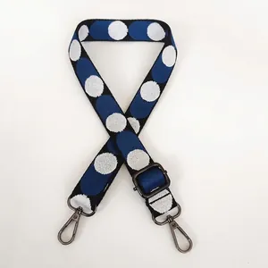 Detail of adjustable woven canvas strap with blue and white pattern and gunmetal hooks