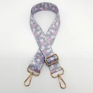 Détail de la bandoulière de sac à fleurs lilas avec mousquetons en métal doré