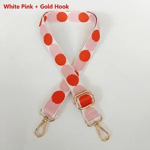 Detail of adjustable canvas strap with pink and orange polka dots and gold hooks