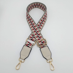 Detail view of adjustable woven shoulder strap with red and black geometric patterns