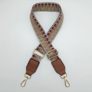 Close-up of ethnic woven strap with geometric patterns and golden metal buckles