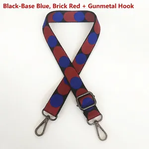 Detail of adjustable woven bag strap featuring blue and red polka dots with gunmetal hooks