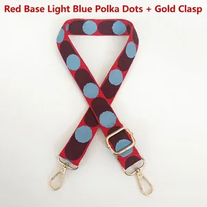 Adjustable woven canvas shoulder strap with red and blue polka dot patterns and gold hooks