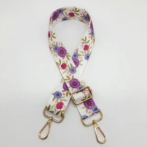 Détail de la bandoulière florale réglable avec fleurs violettes et mousquetons dorés