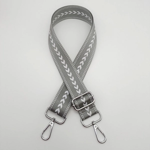 Detail of adjustable grey nylon strap with white arrow pattern and silver metal clasps