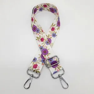 Détail de la bandoulière tissée à fleurs avec mousquetons rotatifs en métal argent