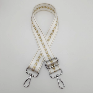 Close-up of adjustable nylon strap with golden arrow embroidery and silver metal lobster clips