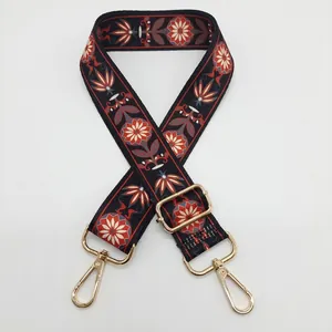 Détail d'une bandoulière ethnique réglable avec motifs floraux et crochets dorés