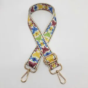 Vue détaillée de la bandoulière à motif papillon coloré avec boucle et réglage dorés