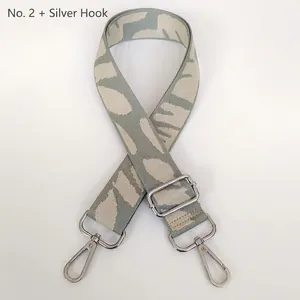 Detail of grey-green leaf pattern woven bag strap with silver metal lobster hooks