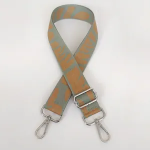Detail of wide fabric backpack strap with mint green geometric pattern and silver hooks