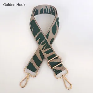 Close-up of wide green and beige zebra pattern canvas strap with gold metal hooks