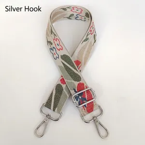 Detail of adjustable floral jacquard strap with silver metal hooks and woven pattern