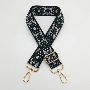 Detail of ethnic style woven strap with geometric patterns and gold metal buckles