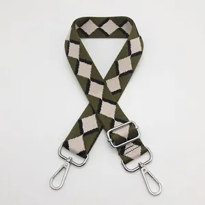 Detail of green argyle patterned jacquard bag strap with silver metal swivel hooks