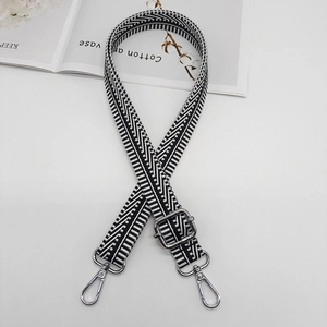 Detail of adjustable black and white striped canvas strap with silver metal hooks