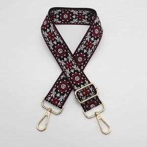 Close-up of ethnic embroidered bag strap with golden metal lobster clasps and patterns