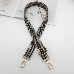 Detail of adjustable black and white wave pattern canvas strap with gold metal hooks
