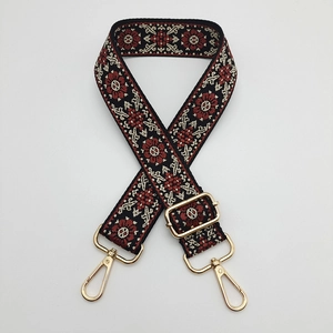 Close-up of bohemian jacquard embroidered bag strap with golden metal lobster clasps