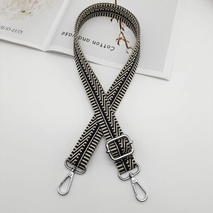 Detail of herringbone woven canvas bag strap with polished silver metal hook and adjuster
