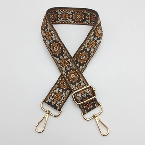 Detail of ethnic embroidery bag strap with golden metal adjusters and lobster clasps