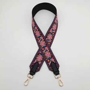 Detailed view of bohemian style embroidered bag strap with golden metal swivel hooks