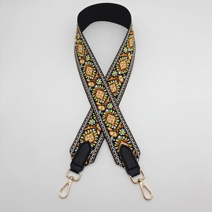 Detail of ethnic embroidered wide shoulder strap with golden swivel hooks and leather ends