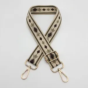 Detailed view of the widened geometric woven shoulder strap with gold metal swivel hooks