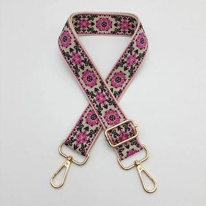 Close-up of ethnic embroidered bag strap with gold lobster clasps and adjustable buckle