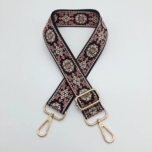 Close-up of ethnic floral jacquard strap with gold-tone metal lobster clasps and buckle