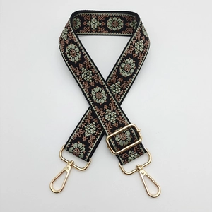 Close-up of ethnic style embroidered strap with floral patterns and golden metal clasps