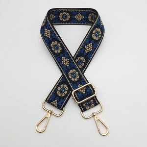 Detail of navy blue ethnic embroidered bag strap with golden hardware and adjust buckle