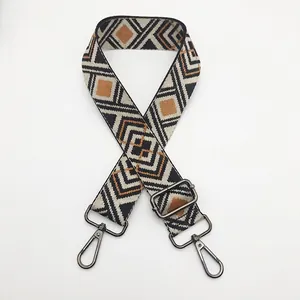 Detail of jacquard woven bag strap with geometric rhombus pattern and gunmetal hooks