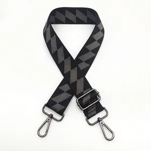 Detail of grey geometric pattern woven bag strap with gunmetal swivel hooks and slider
