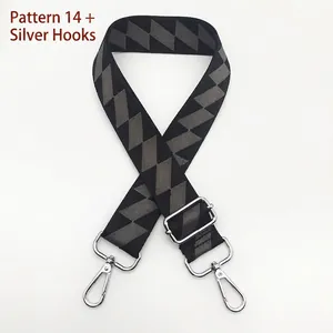 Detail of wide adjustable shoulder strap with grey geometric pattern and silver metal hooks