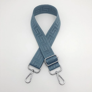 Detail of blue adjustable bag strap with Greek Key pattern and silver metal clasps