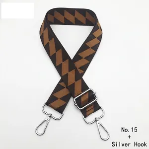 Detail of adjustable geometric patterned bag strap in brown with silver metal hooks
