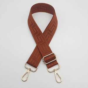 Detailed view of caramel adjustable canvas bag strap with golden metal lobster clasps