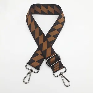 Close-up of brown geometric canvas bag strap with gunmetal swivel hooks and slider