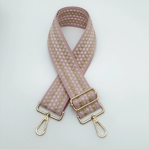 Dettaglio della tracolla in tela intrecciata rosa e oro con ganci a moschettone
