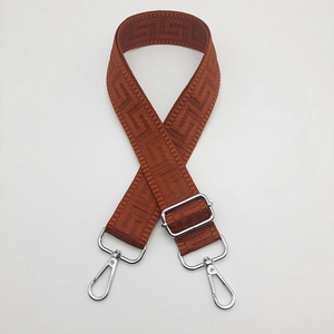 Close-up of adjustable wide canvas shoulder strap with brown Greek key pattern