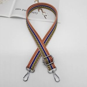 Detail of adjustable woven canvas shoulder strap with multi-color stripes and metal hooks
