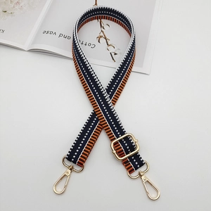 Detail of adjustable navy and orange striped canvas strap with gold metal hooks