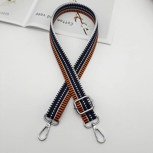 Detail view of adjustable navy and orange striped canvas strap with silver metal swivel hooks